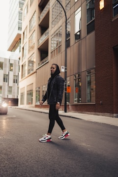 A candid shot of a person walking down a city street in a minimalist hoodie, embodying effortless style.
