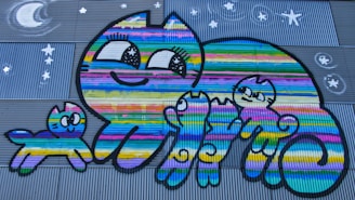 A playful black and white cartoon cat with a wide grin, reminiscent of Felix the Cat, surrounded by colorful toys and playful kids.