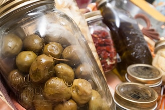 Close-up of a vibrant jar of chicken vindaloo pickle with rustic wooden background.