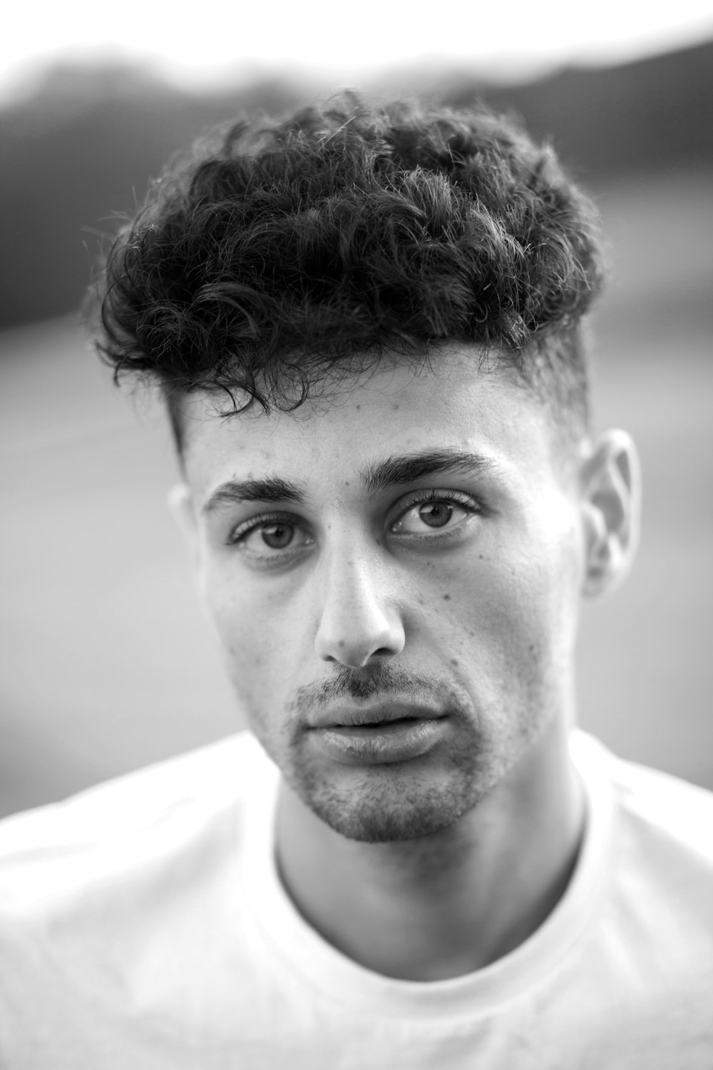 grayscale photography of man wearing crew-neck shirt