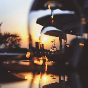 A close-up of a crystal wine glass catching the golden light during a sunset tasting at a San Francisco rooftop.
