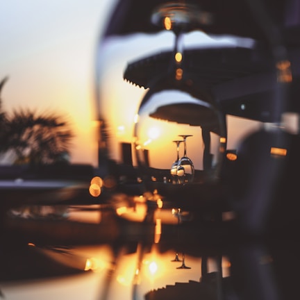 A close-up of a wine glass catching the warm afternoon light, with a blurred vineyard in the background.