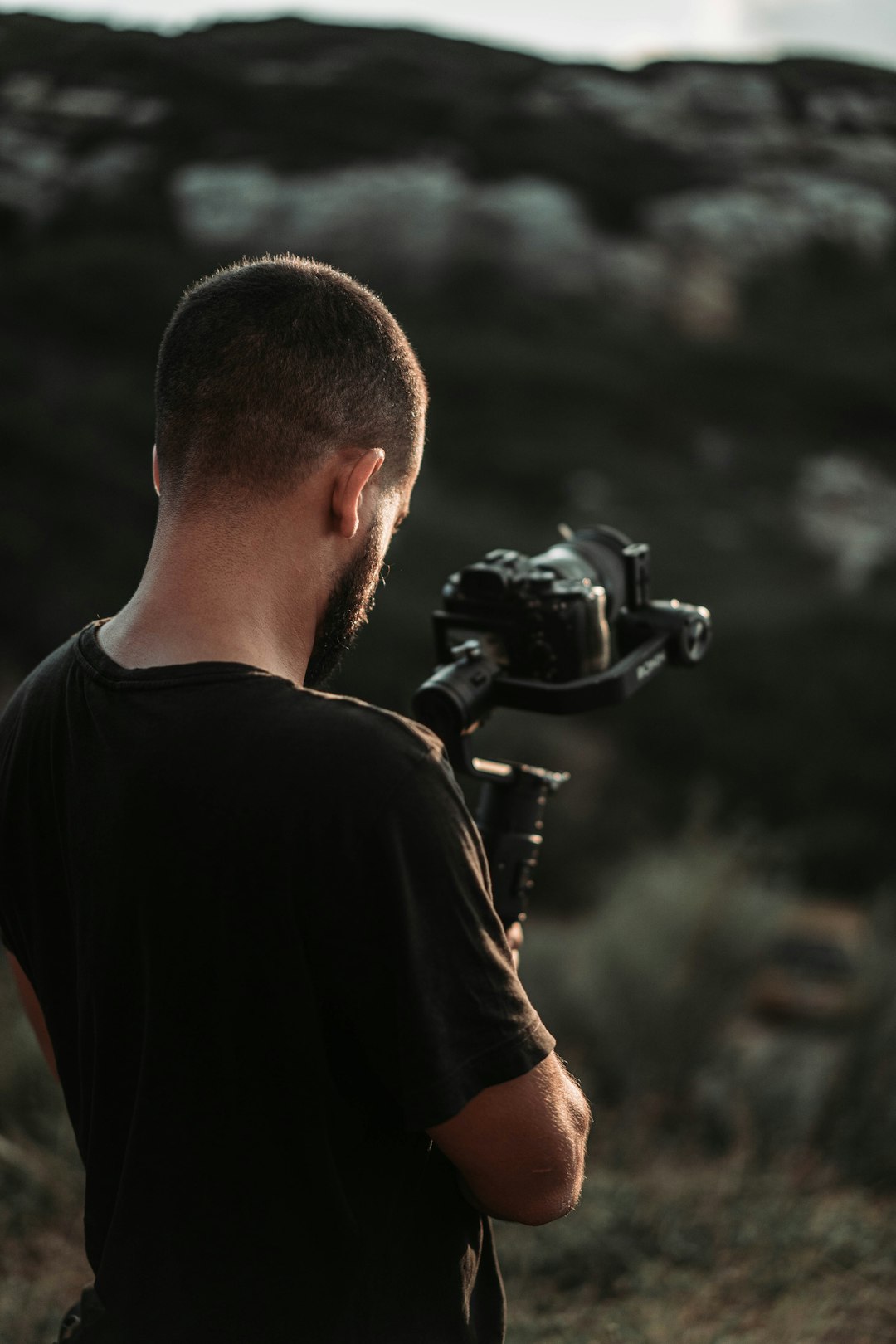 man holding DSLR camera taking photo of forest