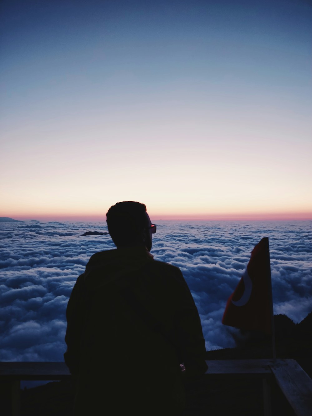 silhouette photo of man overlooking sea of clouds