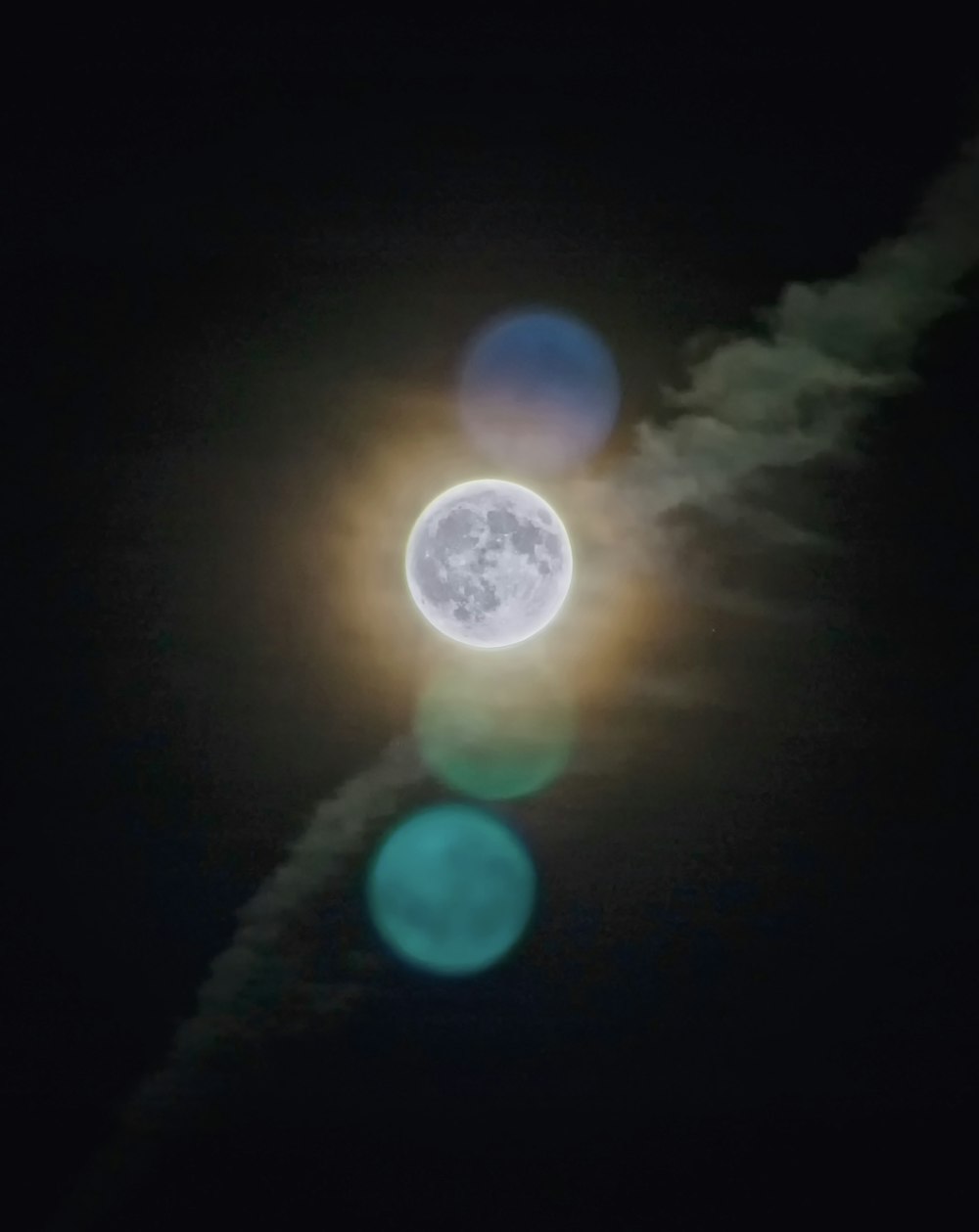 a full moon seen through the clouds in the night sky