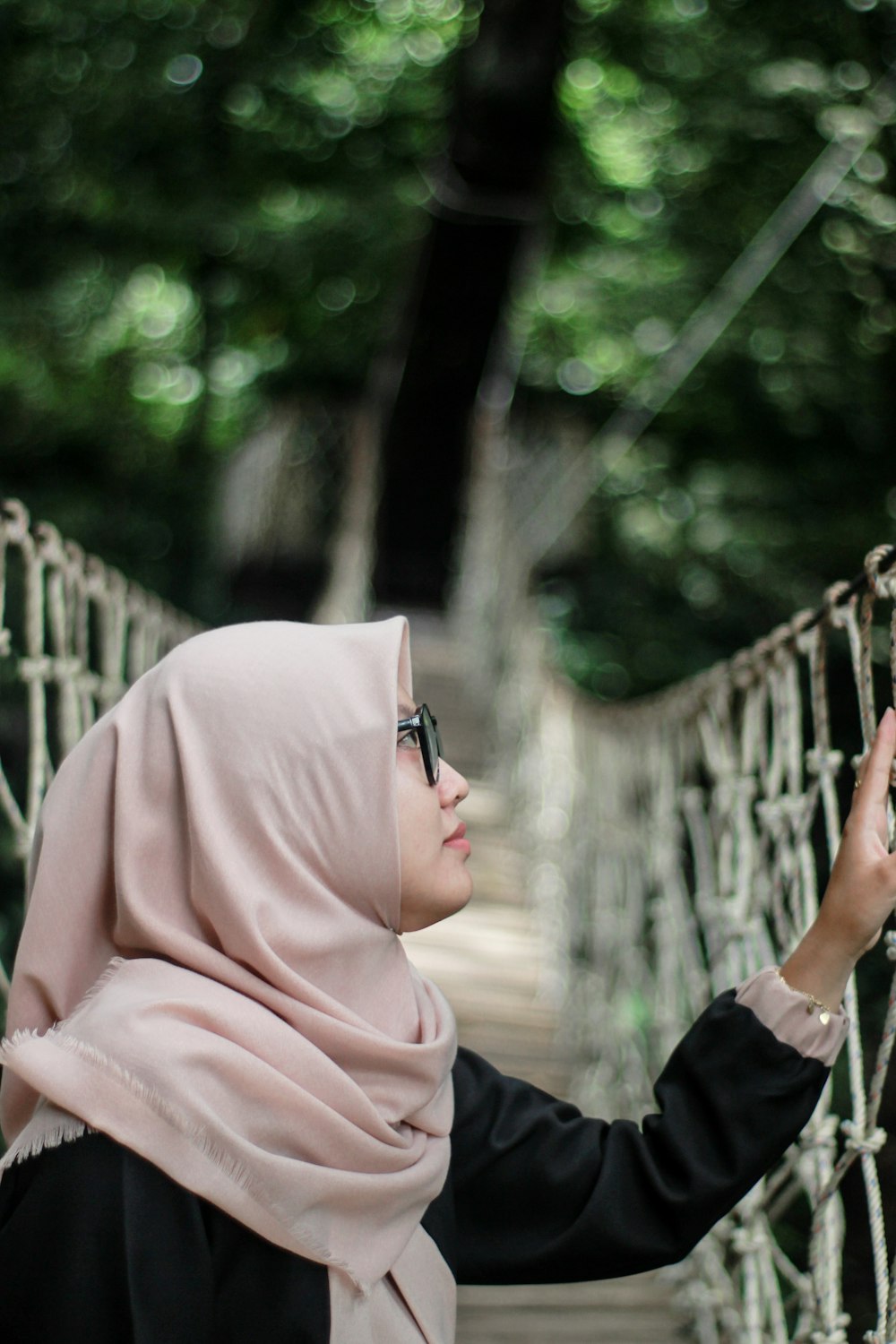 woman wearing beige hijab in hanging bridge