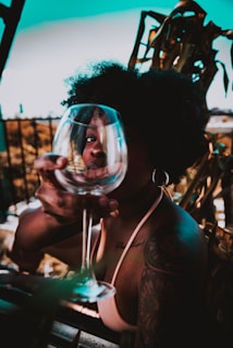 woman holding clear wine glass