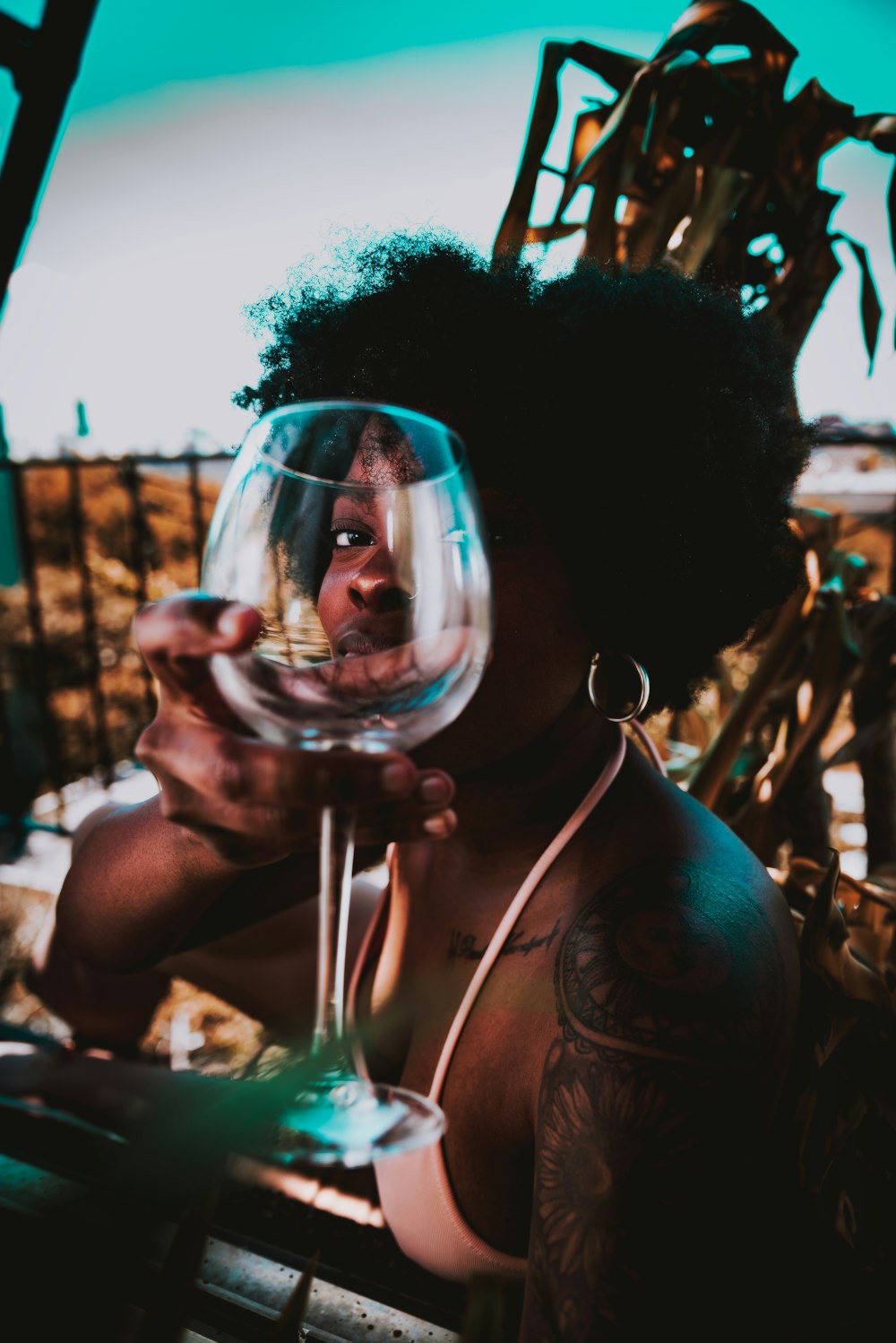femme tenant un verre de vin transparent
