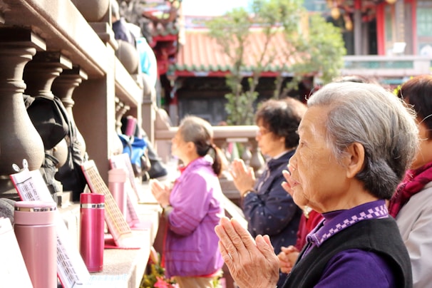 A group of elderly pilgrims smiling warmly as they prepare for their journey.