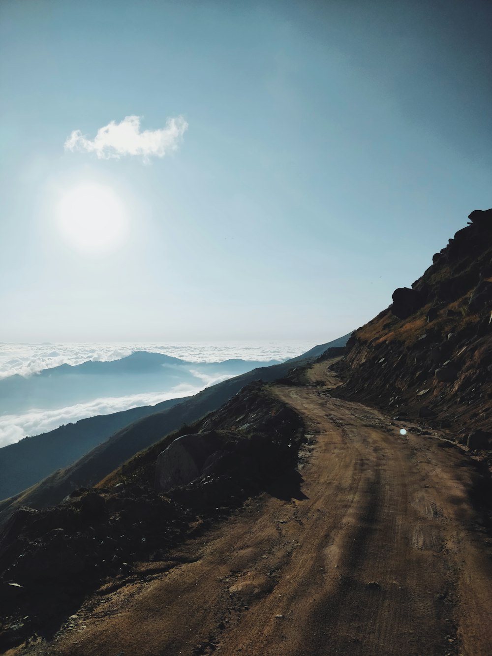 landscape photo of brown raw road and mountain ranges