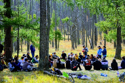 A group circle gathering in a forest setting.