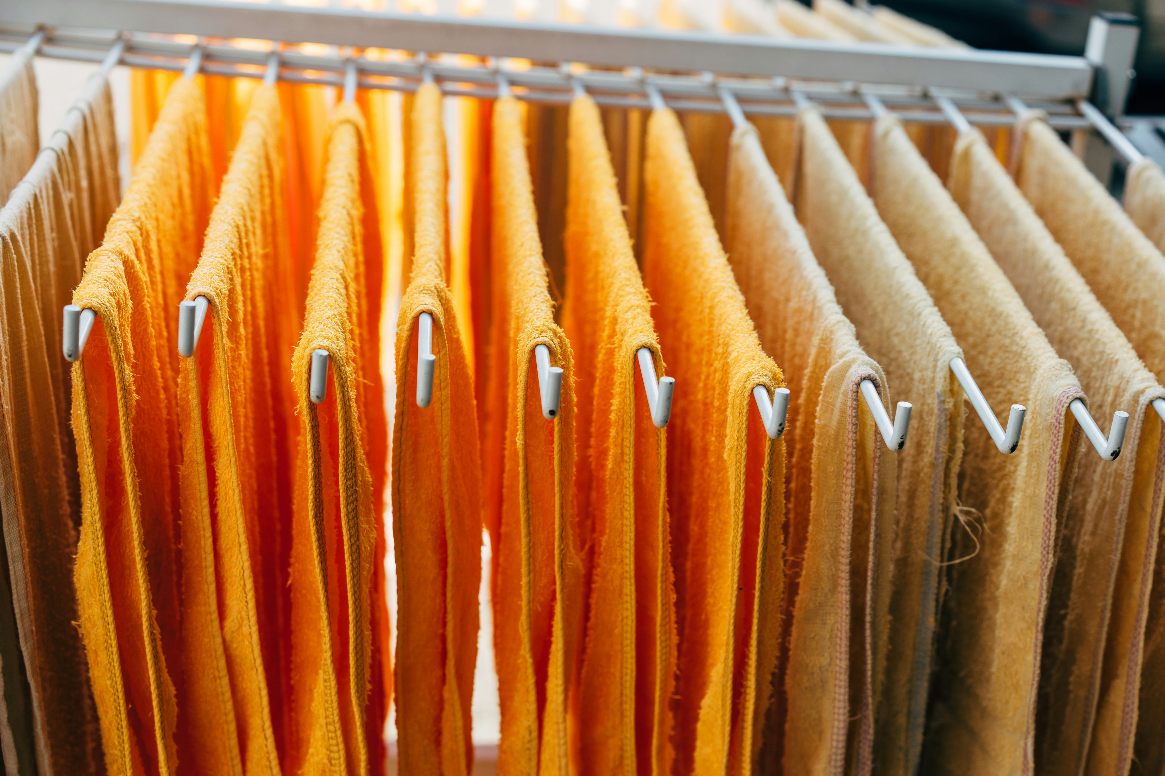 yellow and white towels on white dryer rack