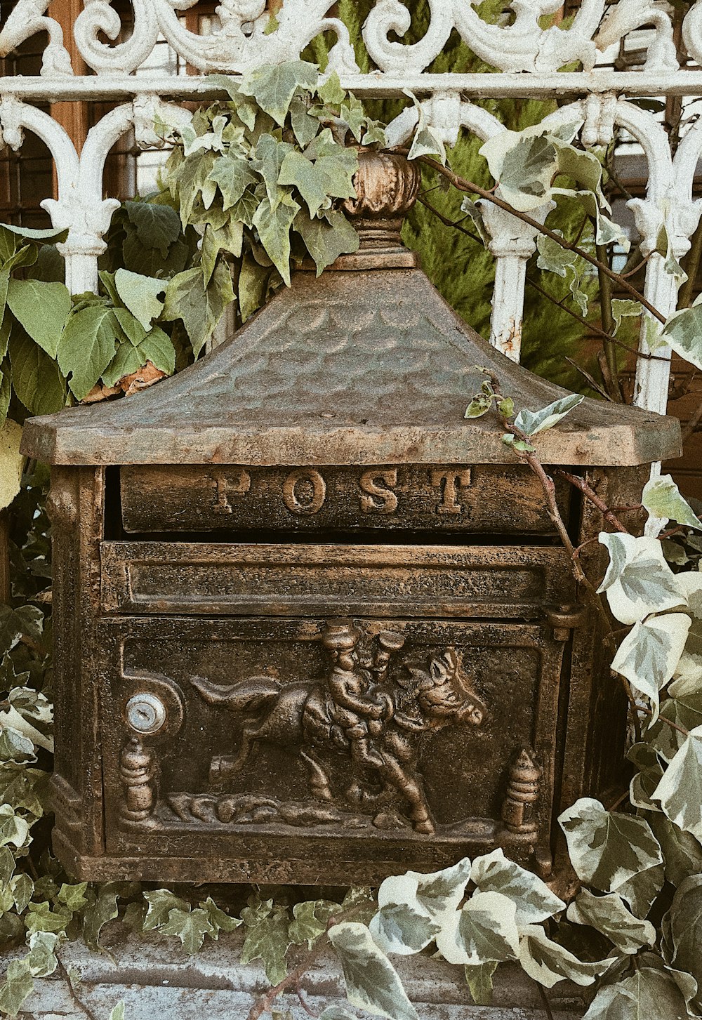 an old mailbox with ivy growing around it