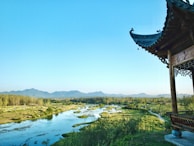 A serene landscape featuring artisans crafting products against a backdrop of nature.