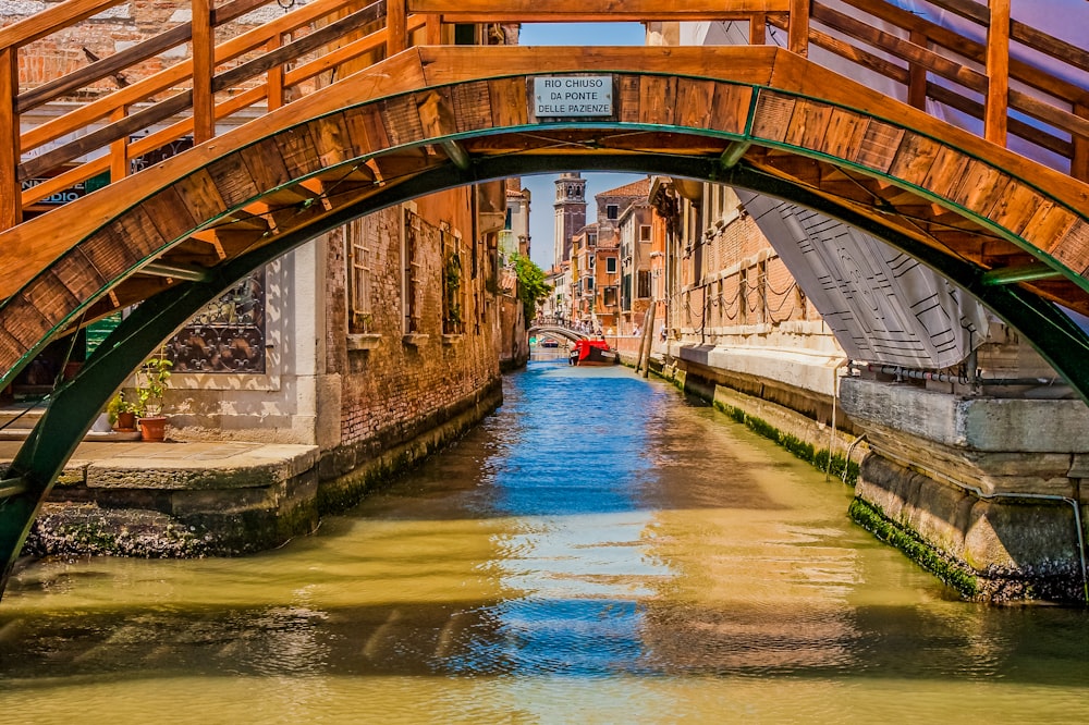 a wooden bridge over a small canal in a city