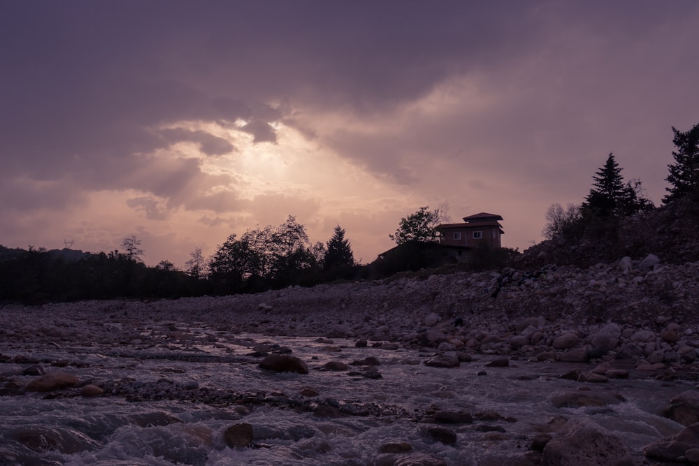 une rivière qui traverse une forêt sous un ciel nuageux