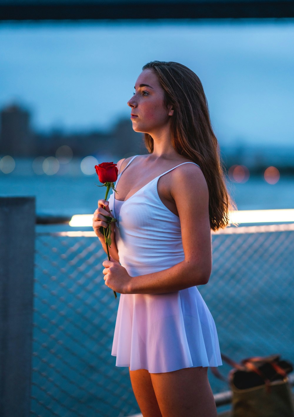 woman holds flower near handrail