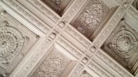 Close-up of detailed plasterwork on a ceiling corner in a renovated room.