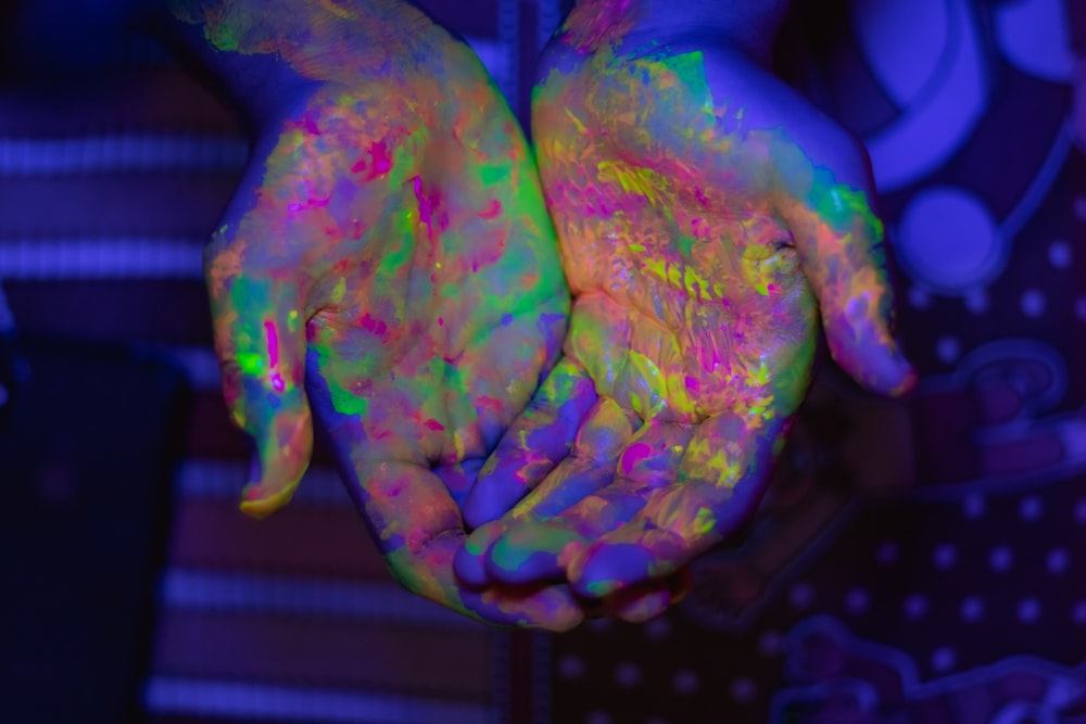 person's hands with paints