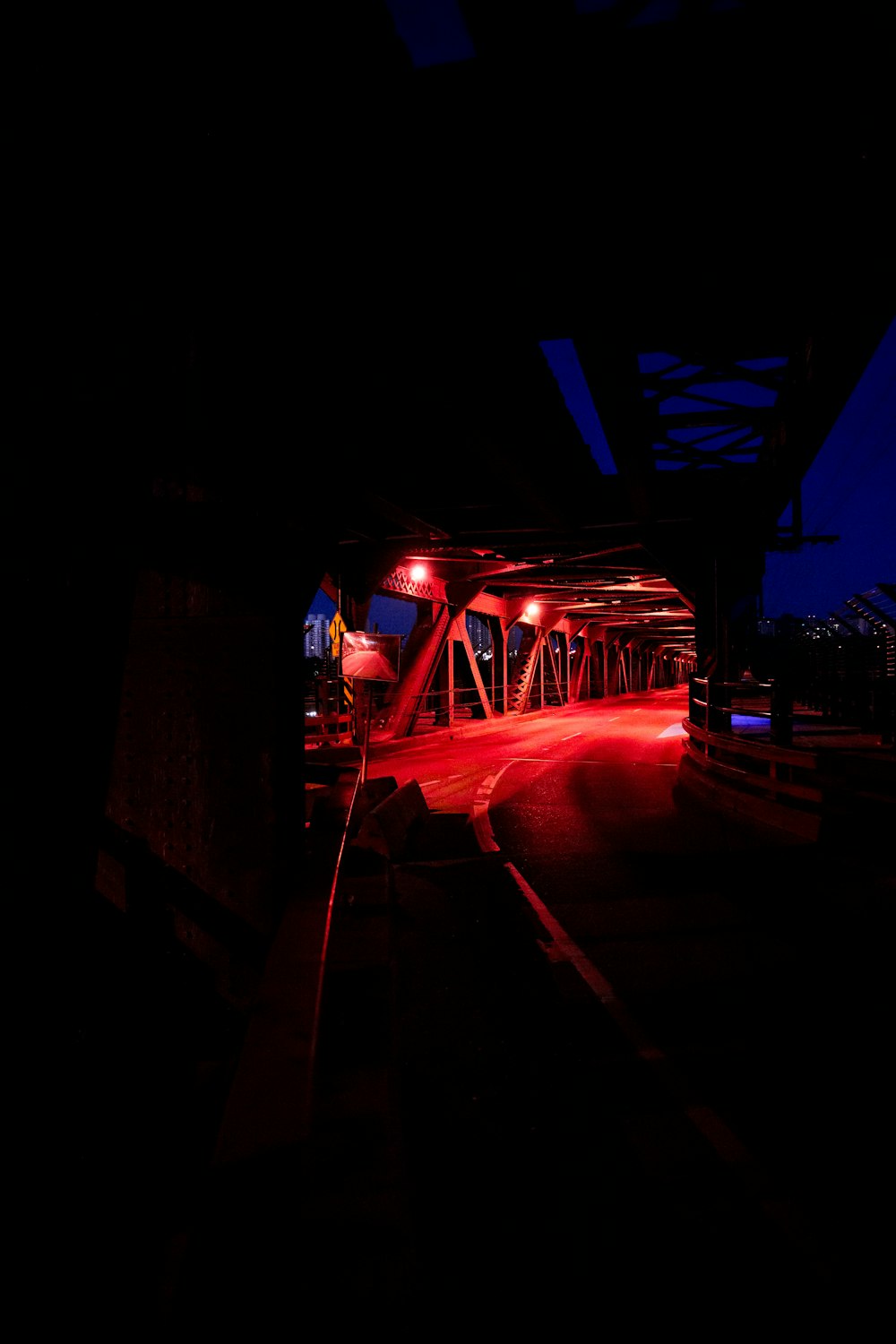 Una luz roja brilla en un puente por la noche