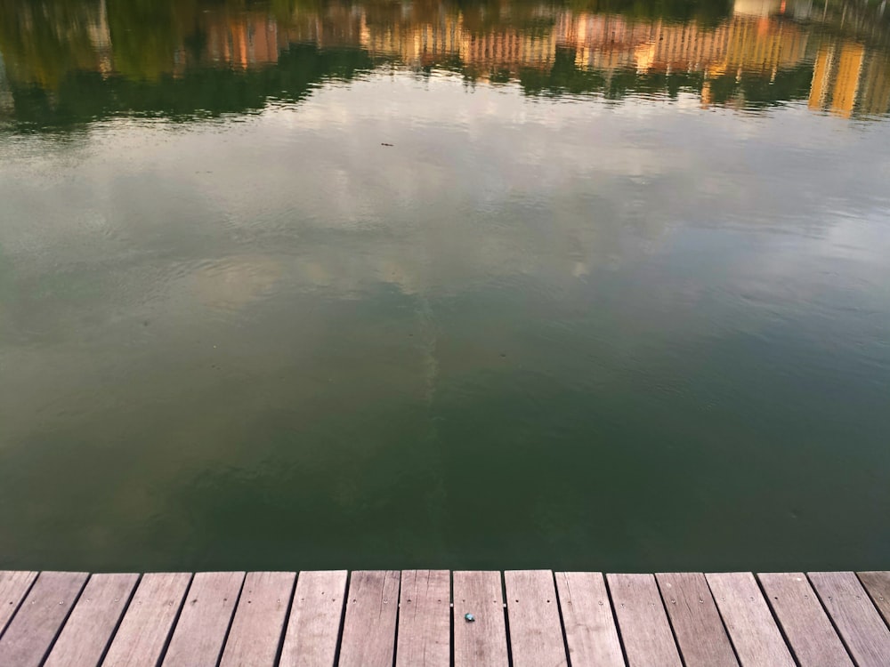 Bacino di legno marrone accanto allo specchio d'acqua