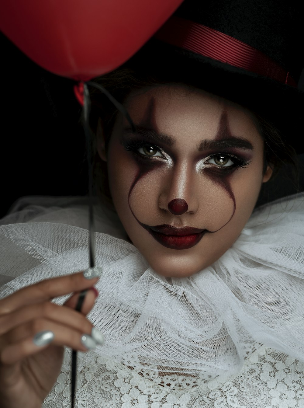 woman wearing clown costume holding red balloon