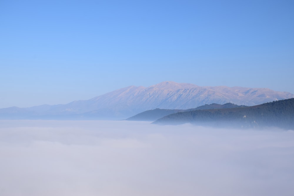 mountain under blue and white skies during daytime