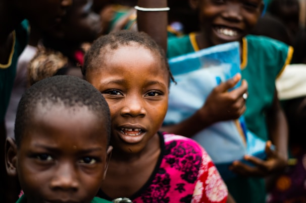 Smiling children receiving gifts during a donation event.