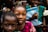 Children playing joyfully at a colorful birthday party with a photographer capturing the moments.
