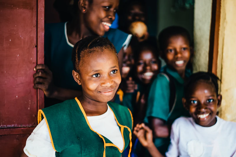 Smiling school children at a classroom door in Sierra Leone