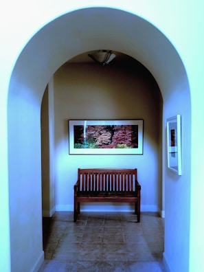 A hallway wall adorned with a simple gallery of framed prints and a rustic wooden bench.