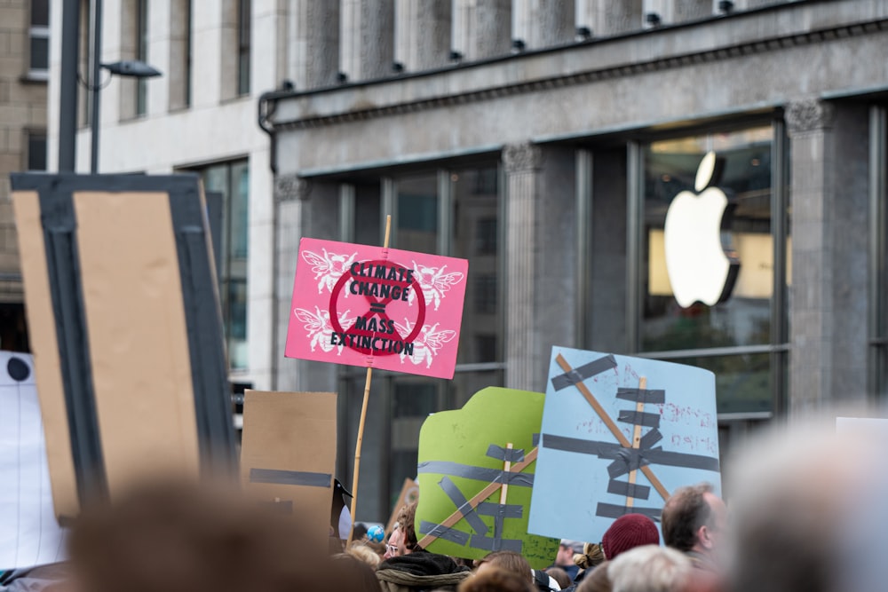 a group of people holding signs in front of a building