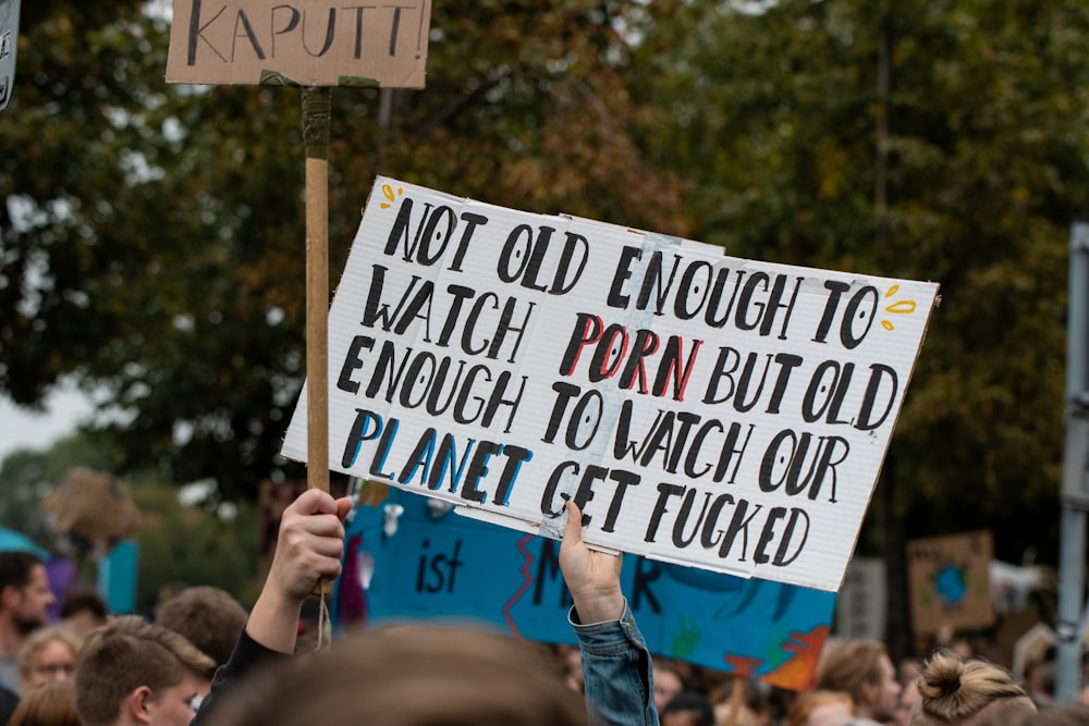 shallow focus photo of person holding signage