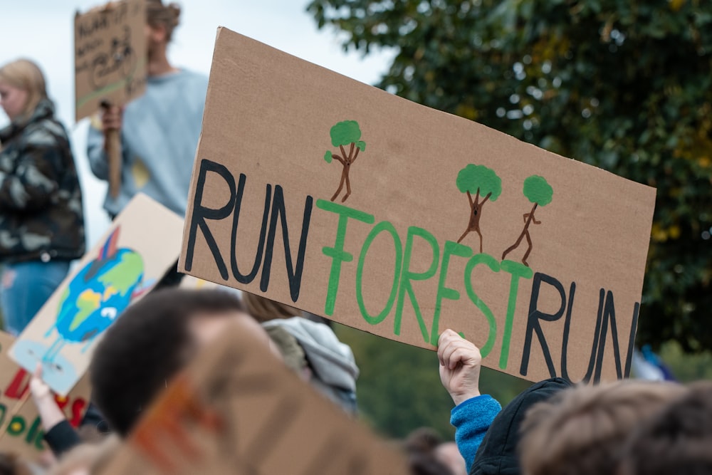 person holding up run forest run sign