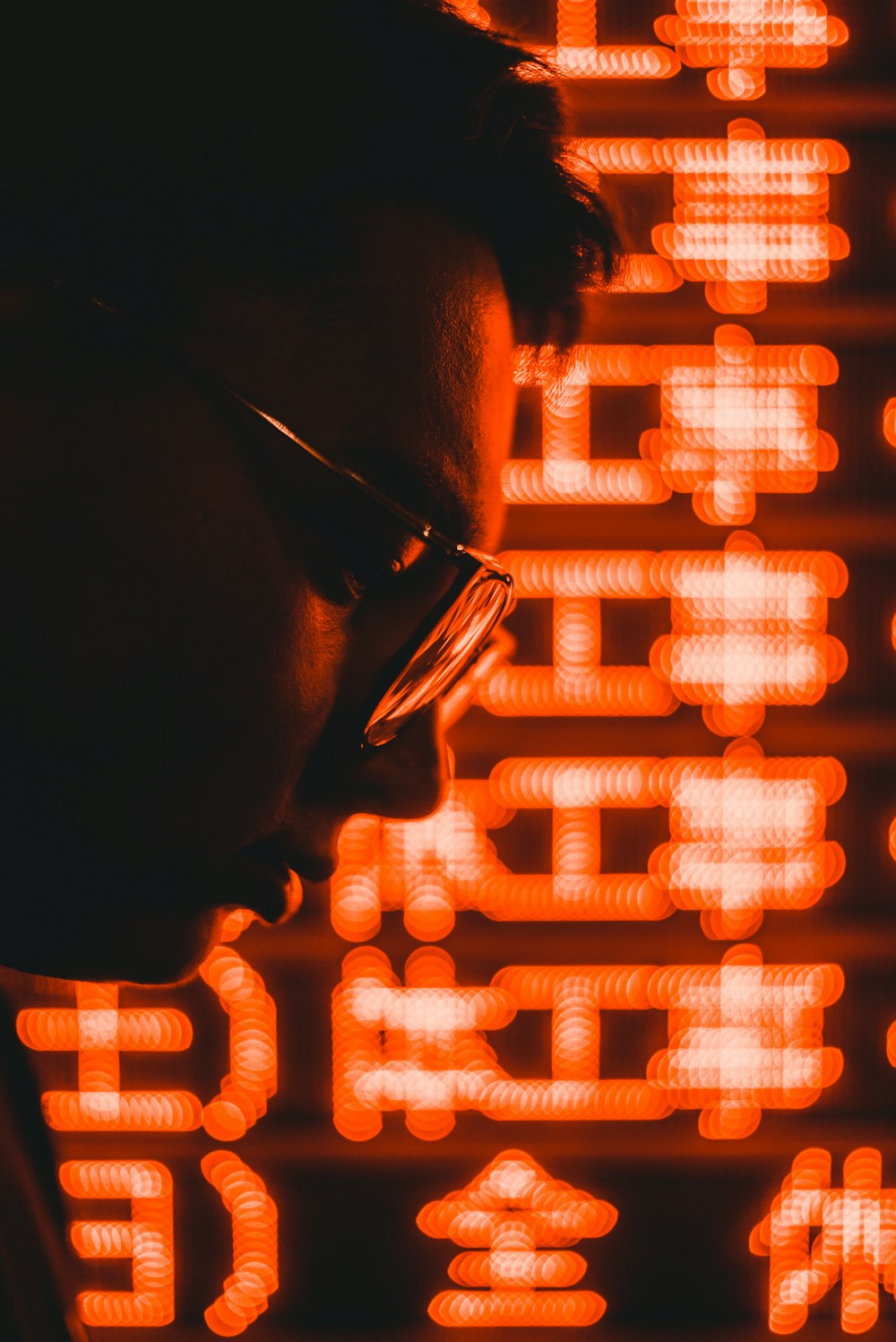 man wearing eyeglasses while looking down