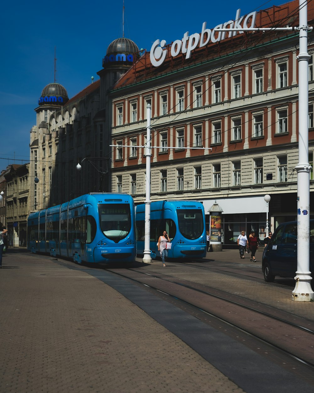 two blue trains beside OTP banka building