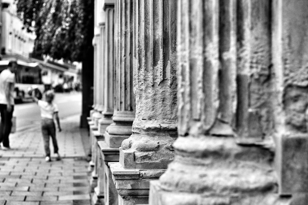 boy and man walking on sidewalk during day