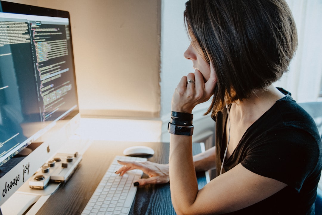 Woman sitting at a desk in front of coding computer screen