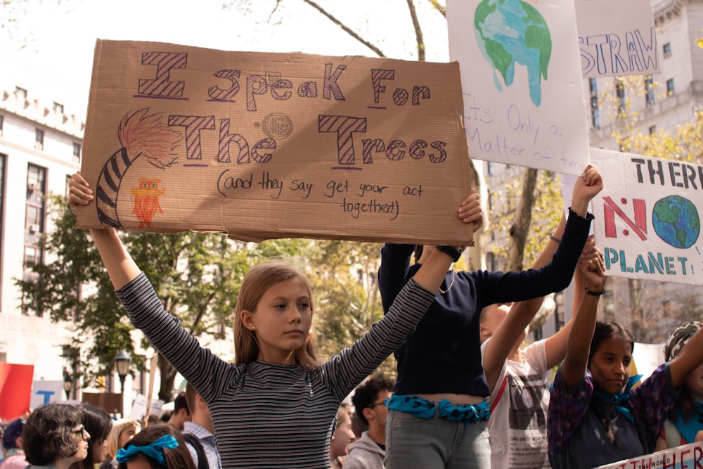 woman holding signage at daytime