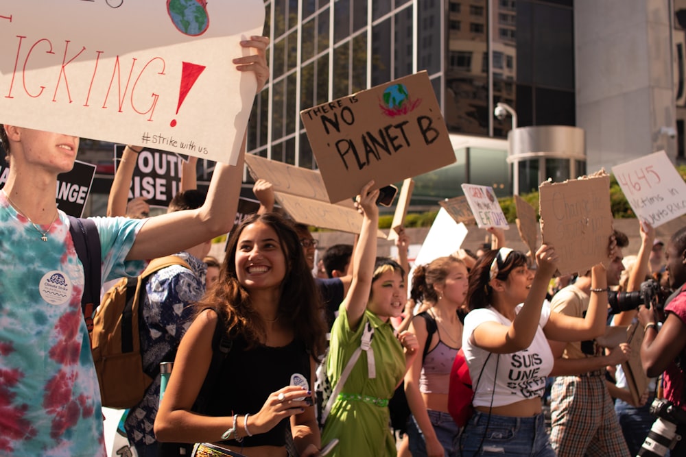 peopled standing on road holding signage at daytime