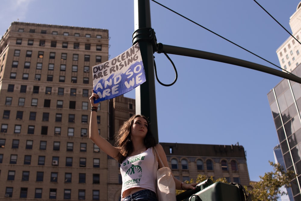 woman holding white and blue placard