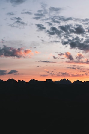A scenic view of a mountain range at sunset.