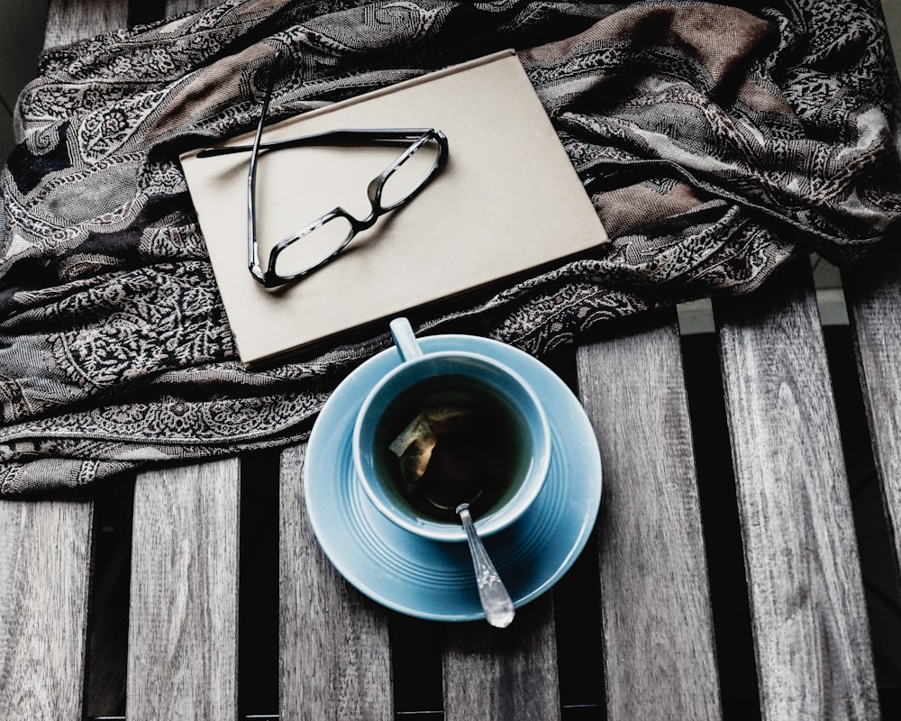 xícara de chá de cerâmica azul com líquido preto