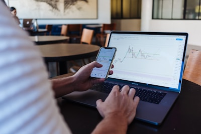 person using smartphone and MacBook Pro