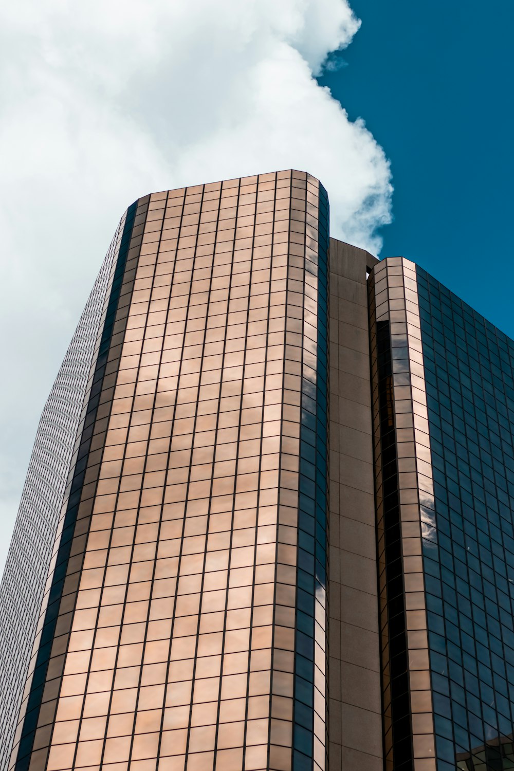 low-angle photography of brown and blue high-rise building