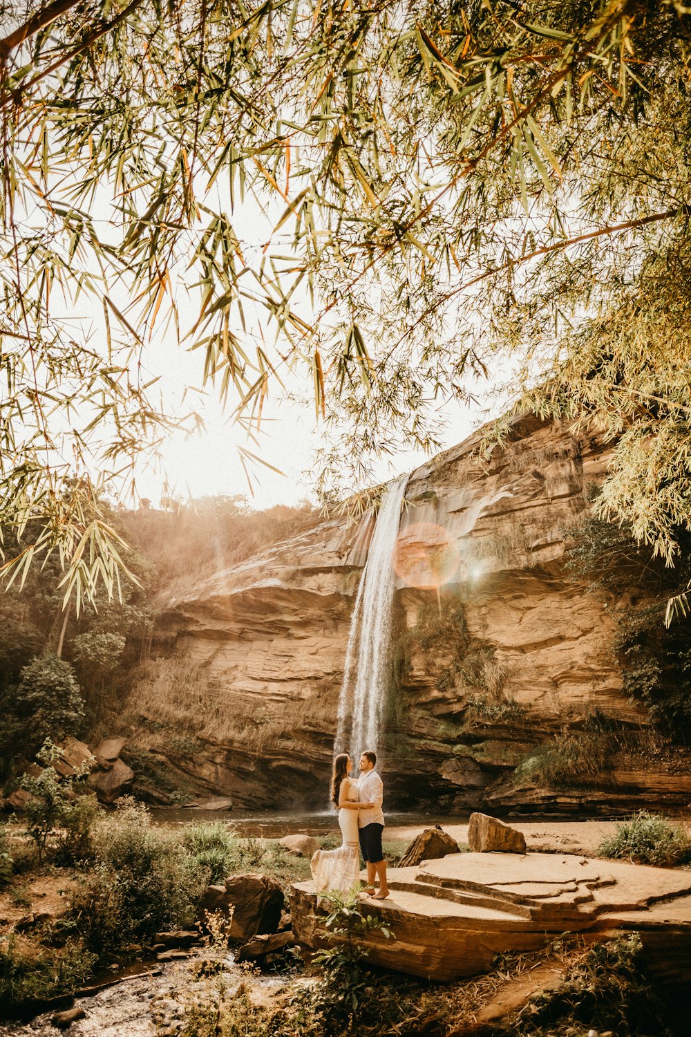 man and woman near water falls