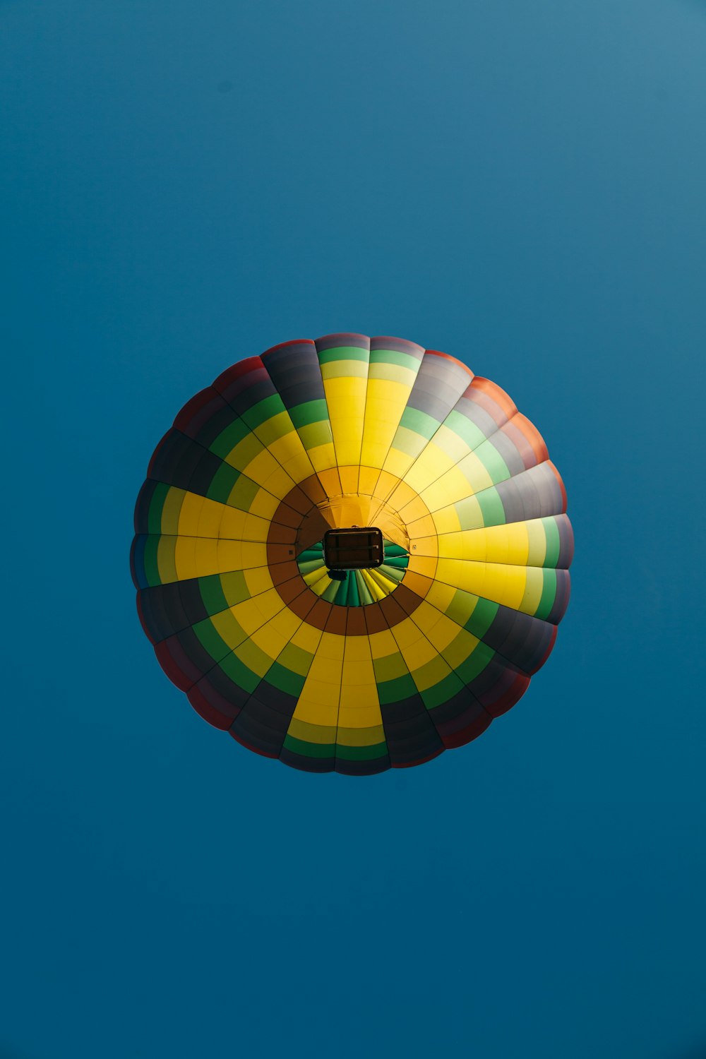 floating yellow, black, and orange hot air balloon