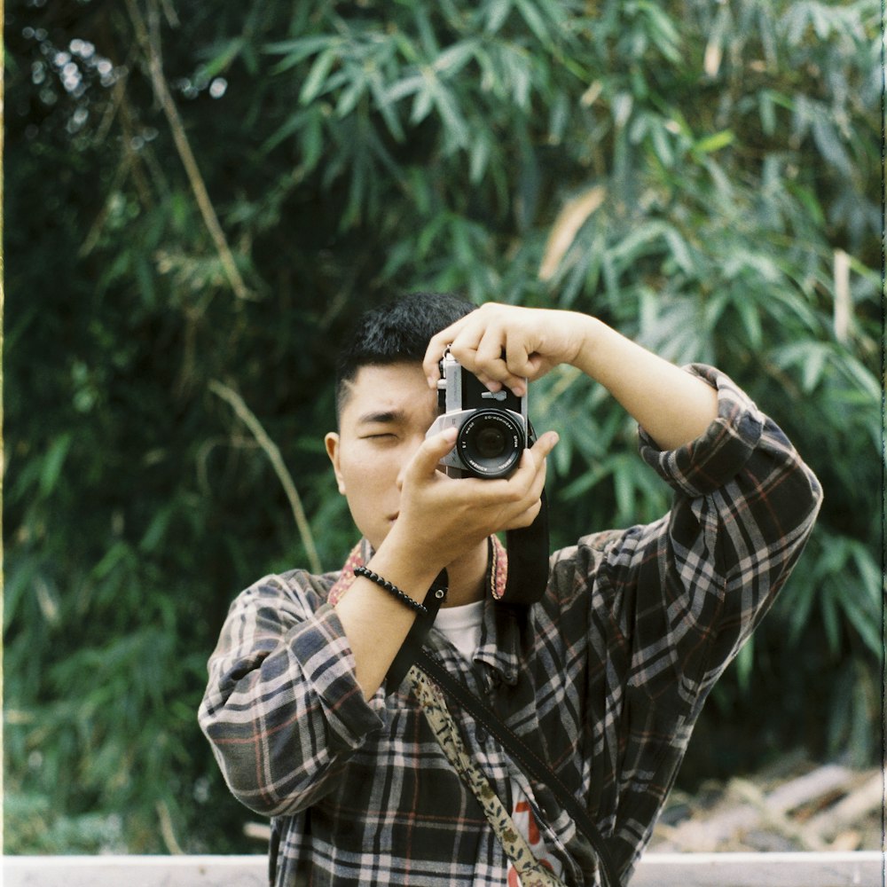 man holding black and gray camera during daytime