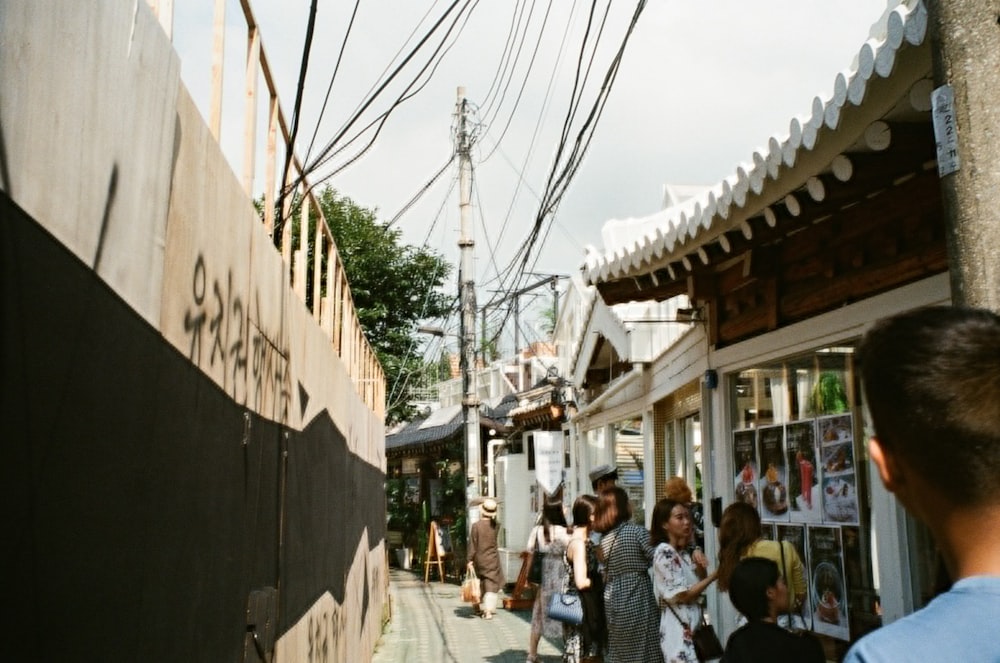 people standing near store beside buildings during daytime