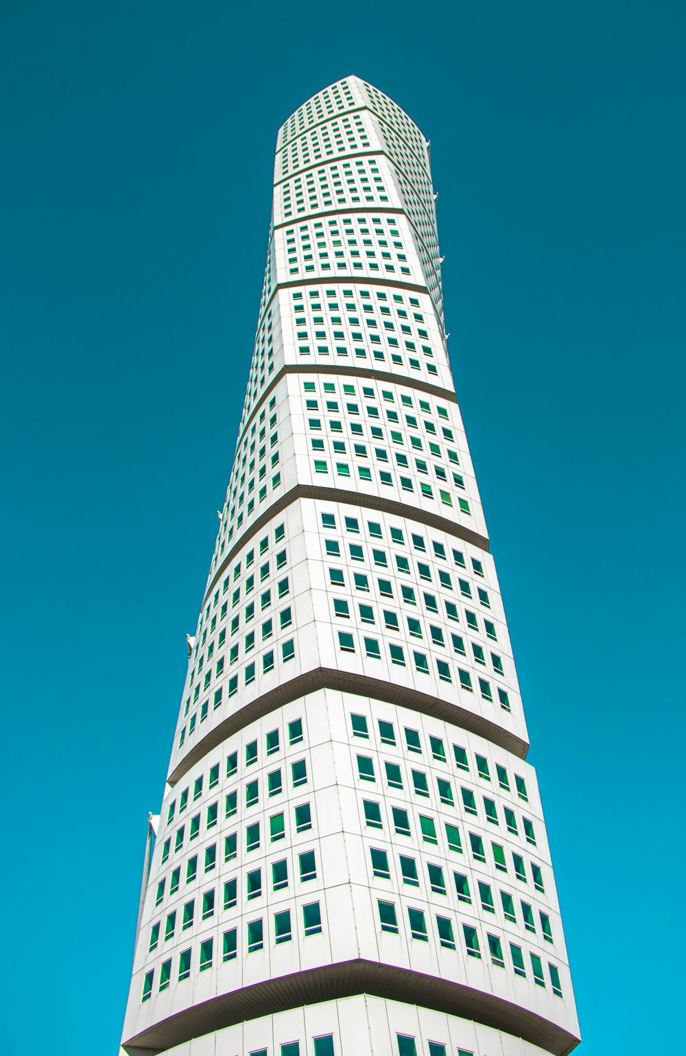 white twisted building under blue sky